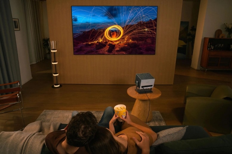The couple is enjoying a brightly lit video in the room.