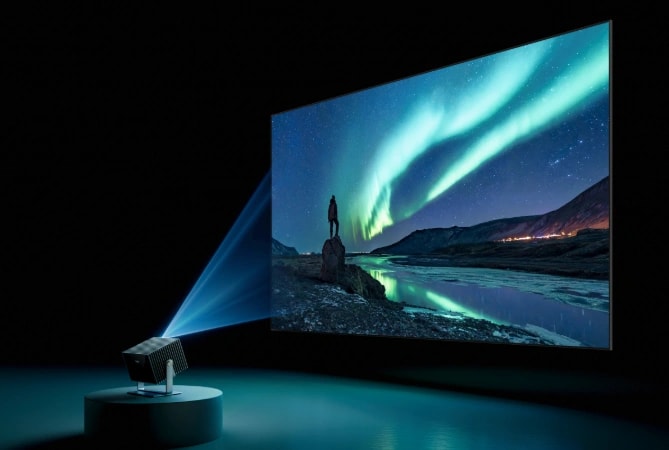 A laser projector displays a vivid image of an aurora landscape.